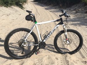 Noseless bike seat by Spongy Wonder on a beautiful Breezer mountain bike seen at the beach. 